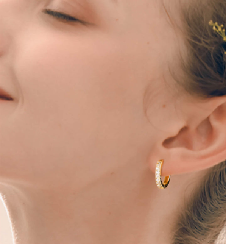 Close-up of a person wearing 14k Gold Plated Huggie Hoop Hoops Cartilage Earlobe Piercing