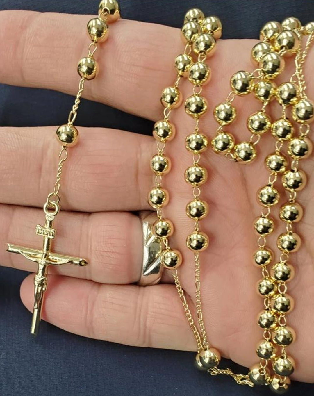 Gold rosary held in a hand against a dark background.  Catholic Rosary Pray Beads Necklace with Virgin Mary Medallion Cross Crucifix 14k Gold Plated Rosarios Catolicos Con Virgen Oro Laminado