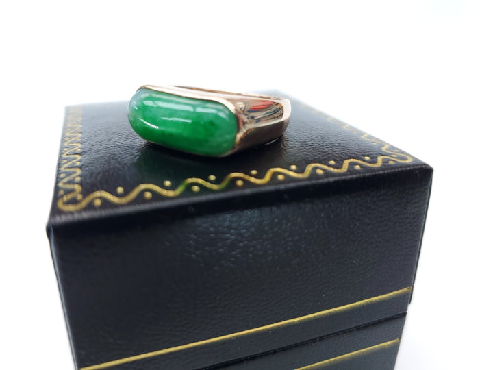 Green jade ring on a black jewelry box with gold accents